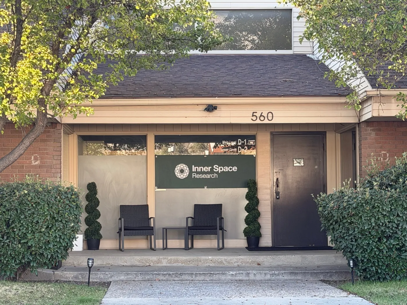 The front porch at 560, with the green Inner Space Research sign in the window and the door to its right