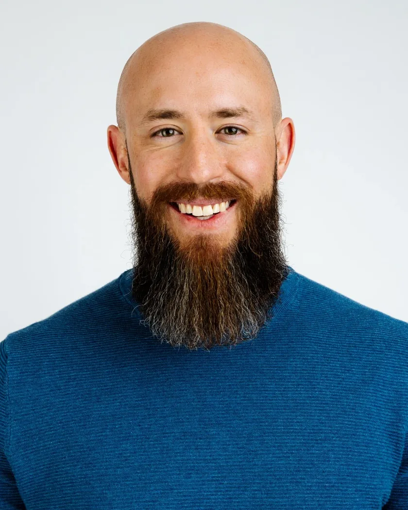 Dr. Steve Thayer, CEO. A smiling man with a full beard wearing a blue sweater, against a plain light background.